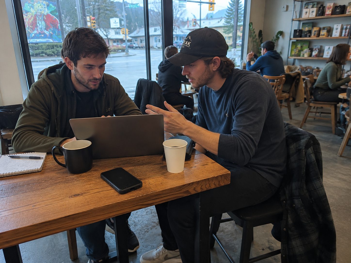 Two people talking over laptops in a casual conversation