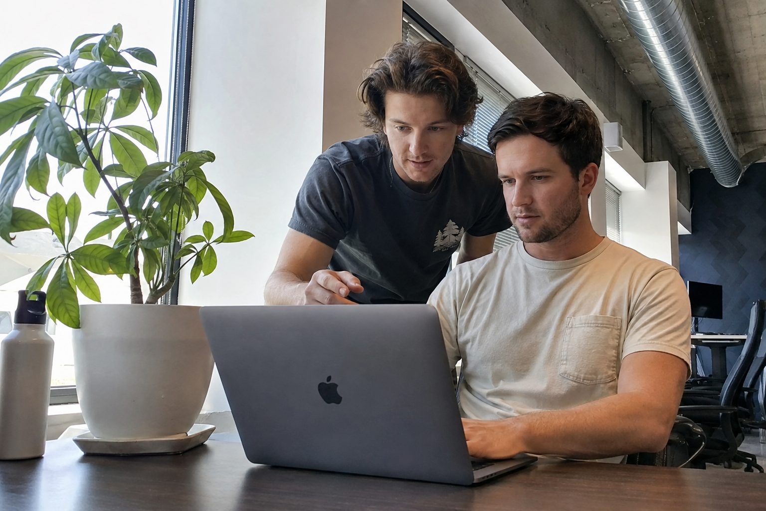 Two EverydayMetrix team members reviewing a laptop together